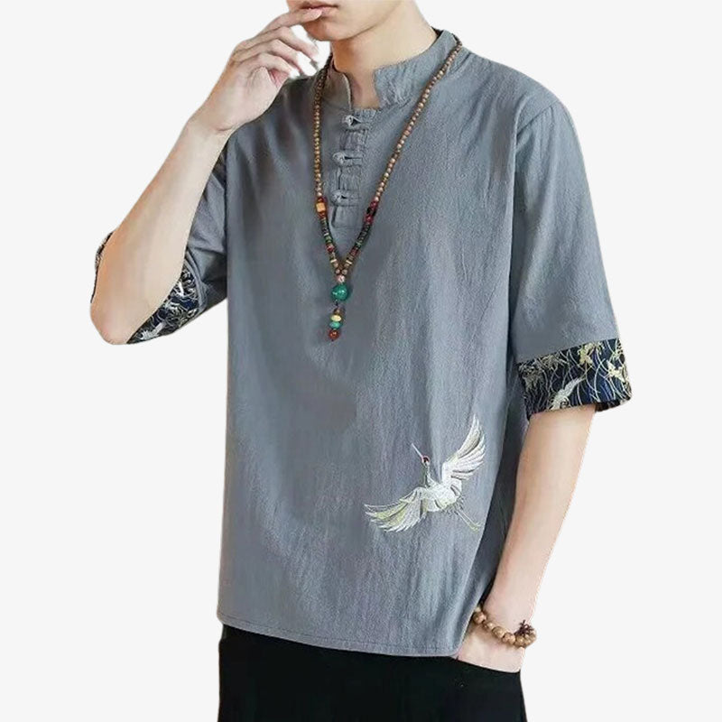 Un homm est vêtu d'un t-shirt traditionnel avec une broderie japonaise symbolisant un oiseau japonais