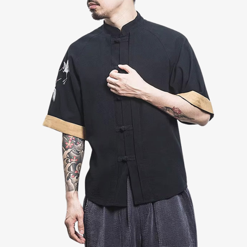 Homme portant un t-shirt japonais noir aux détails raffinés et motifs discrets de grues Tsuru, entre simplicité et identité culturelle
