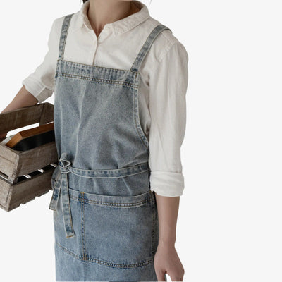 Tablier denim bleu classique, avec bretelles croisées et grande poche avant, alliant design workwear traditionnel japonais et durabilité moderne.