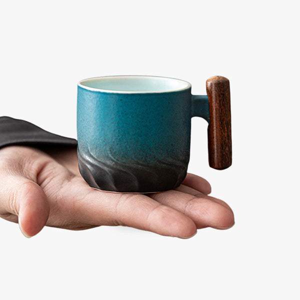 Une tasse artisanale japonaise avec un manche qui tient dans une main