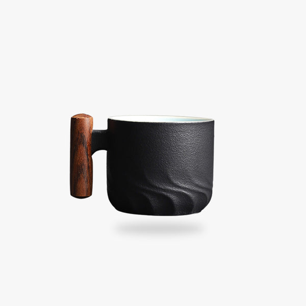 une tasse japonaise ancienne avec un manche en bois. Tasse en céramique de couleur noir