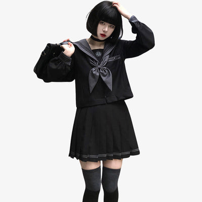 Uniforme scolaire japonais noir composé d’une chemise à manches longues, d’un ruban gris, d’une jupe courte plissée et de chaussettes hautes noires, en coton et matière synthétique.