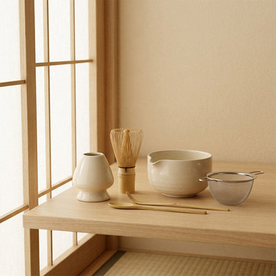 Ustensiles japonais pour le matcha sur une table en bois près d'une fenêtre shoji