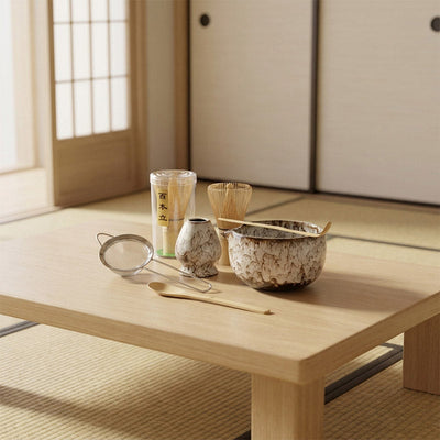 Ustensiles à thé japonais sur une table en bois dans une pièce traditionnelle washitsu