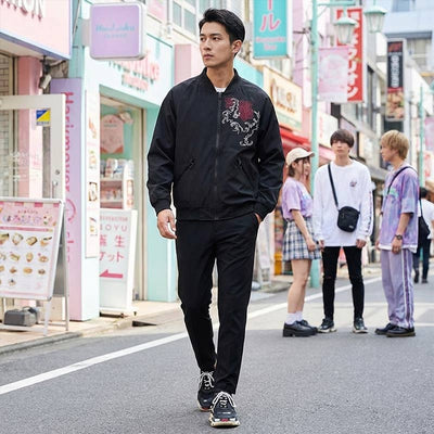 Homme portant une veste bomber japonaise brodée dans un décor urbain