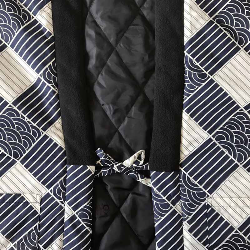 Une veste hanten homme molletonné et fermé avec un noeud. Le col du manteau japonais est noir. Le tissu est imprimé avec des motifs japonais traditionnels