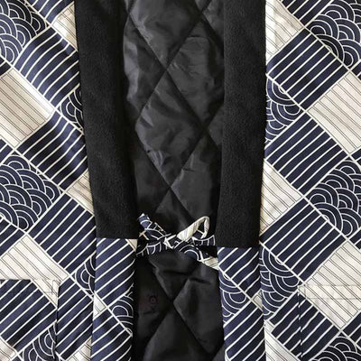 Une veste hanten homme molletonné et fermé avec un noeud. Le col du manteau japonais est noir. Le tissu est imprimé avec des motifs japonais traditionnels