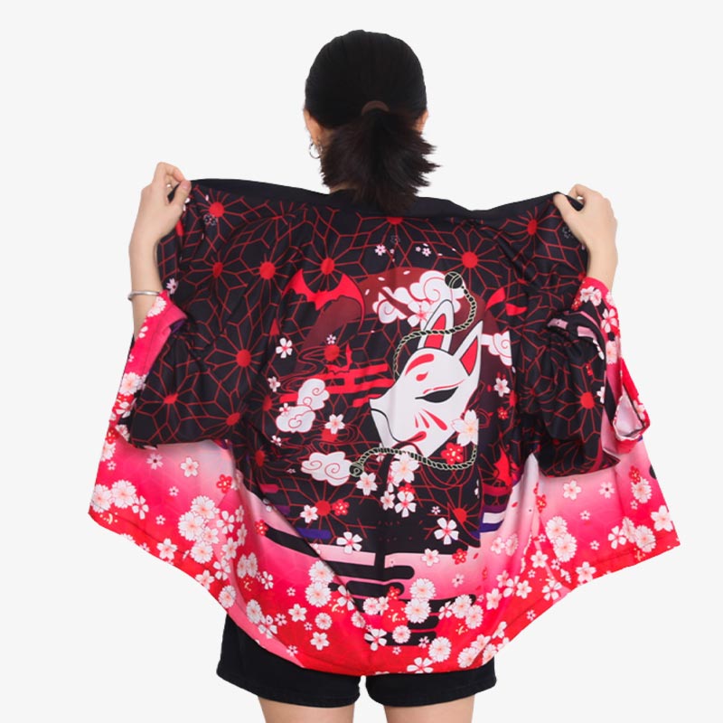 Une femme japonaise est habillée avec un kimono femme Kitsune. Il y a aussi des fleurs de cerisier imprimées dans le dos de la veste haori femme