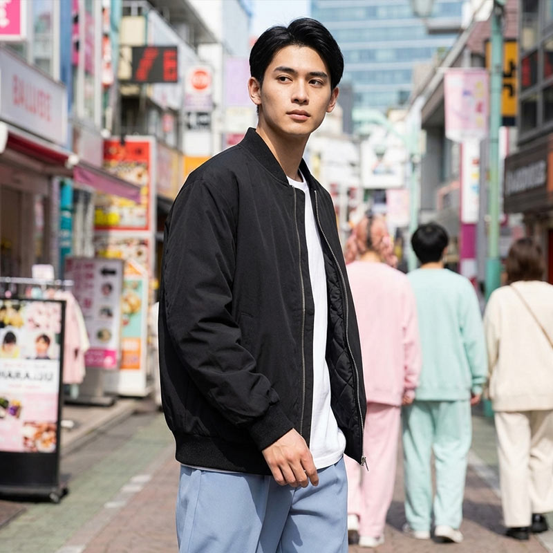 Homme portant une veste sukajan noire dans une rue animée de Harajuku, entourée d'enseignes colorées