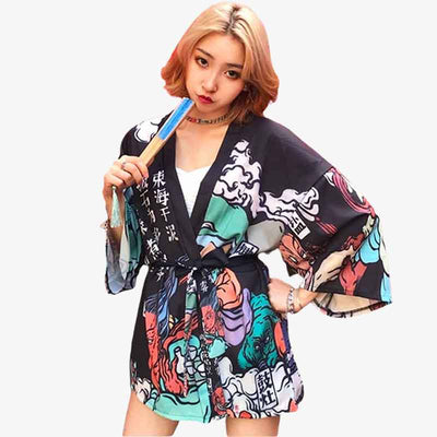 Une femme japonaise est habillée avec une veste style kimono femme. La veste haori a des Kanji et des dessins imprimés sur le tissus douce est 