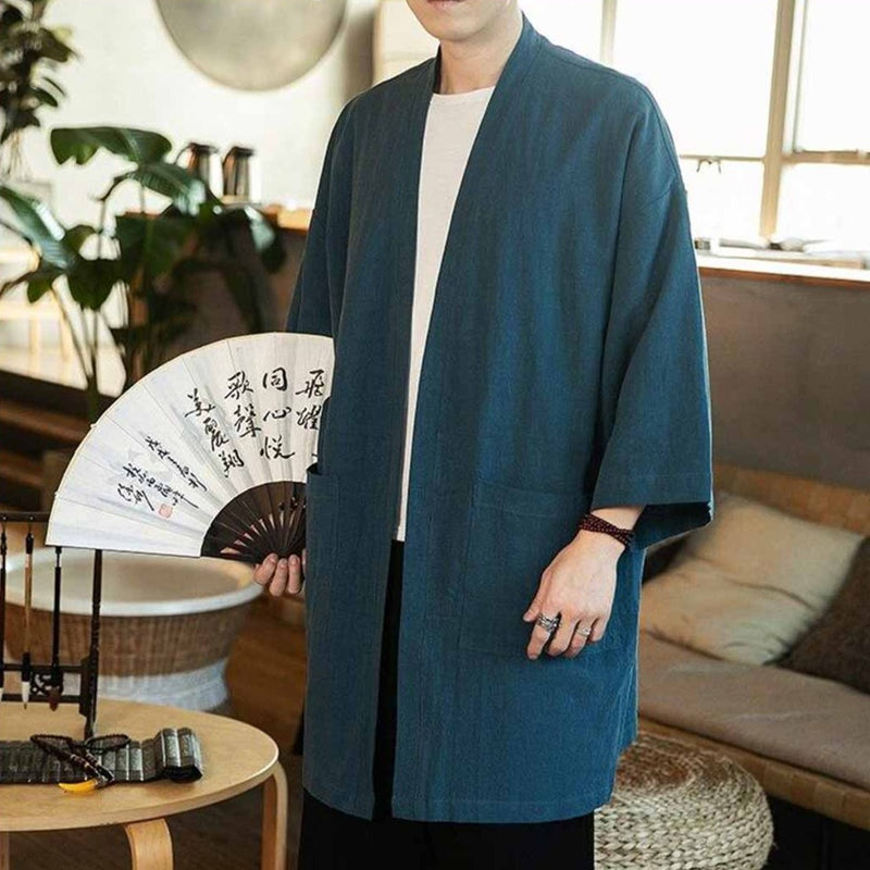 Un homme portant un kimono cardigan japonais de couleur bleu avec un t-shirt blanc à col rond