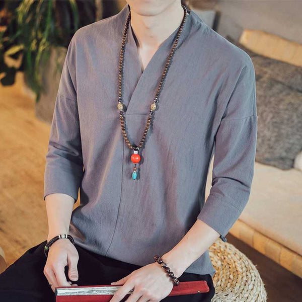 Un homme porte un japon T-shirt en matière en lin. Il a autour du coup un collier en perles zen