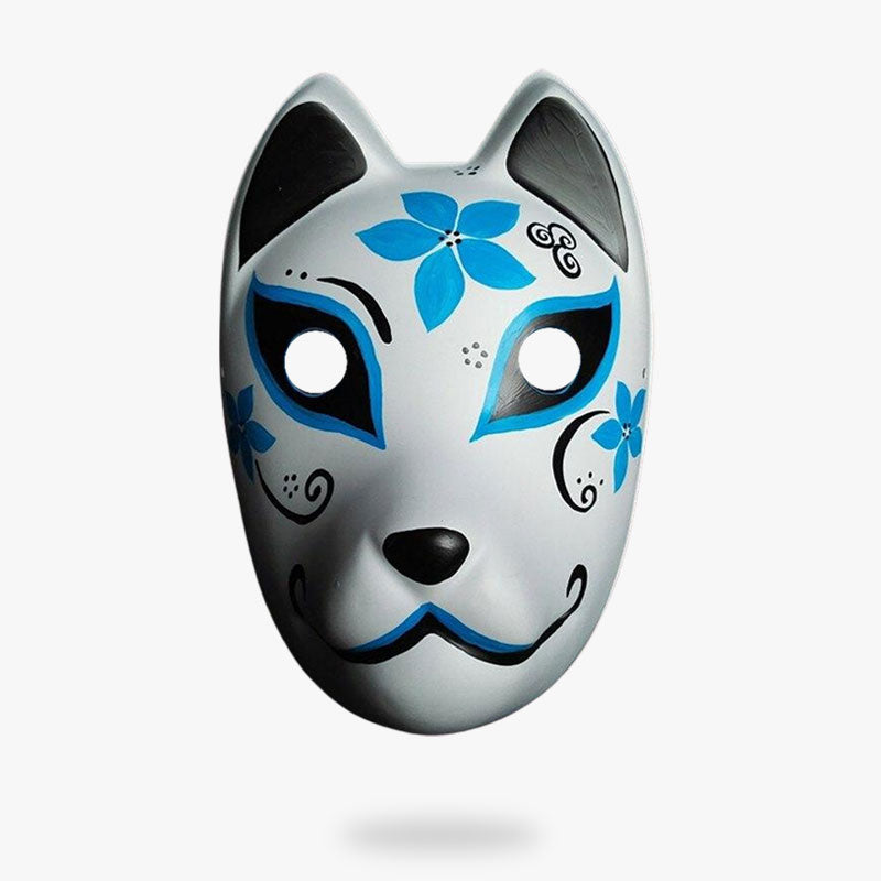 Le masque de renard japonais est blanc et peint avec des fleurs japonaises bleues
