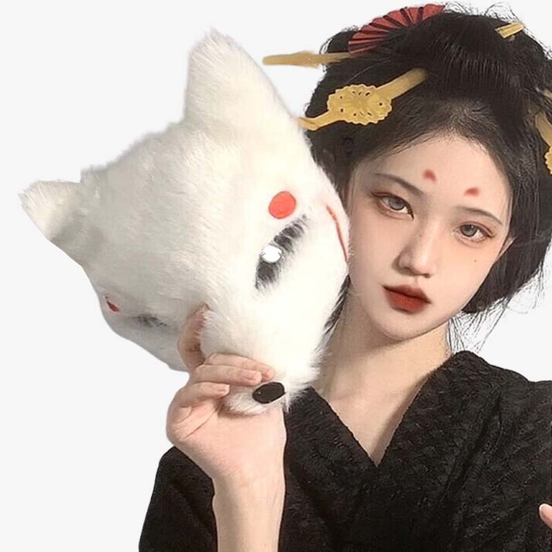 Une femme geisha porte dans la main un masque japonais renard. Elle a un kimono noir et un peigne kanzashi dans les cheveux
