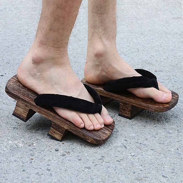 Un homme porte une paire de sandales japonaises avec les pieds nus