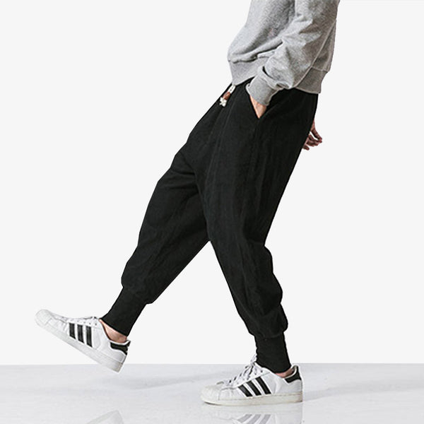 Un japonais porte un pantalon cargo homme streetwear avec des baskets adidas et un sweatshirt gris