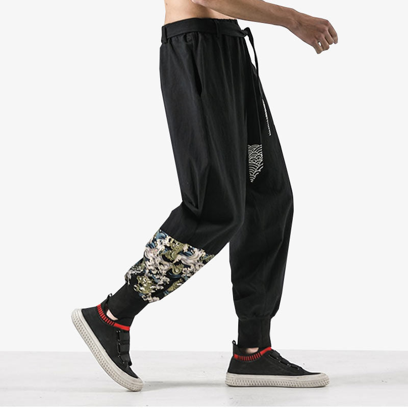 Un hommr potr un jogging noit qui est un pantalon japonais traditionnel Paris. Splendide pièce cousue avec des motifs japonais de dragon et vague (seigaiha)