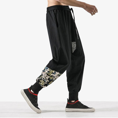 Un hommr potr un jogging noit qui est un pantalon japonais traditionnel Paris. Splendide pièce cousue avec des motifs japonais de dragon et vague (seigaiha)