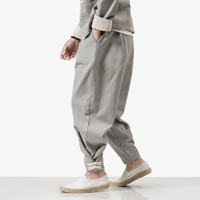 Un japonais porte un pantalon ninja homme de couleur grise. Ainsi que des chaussures japonaises