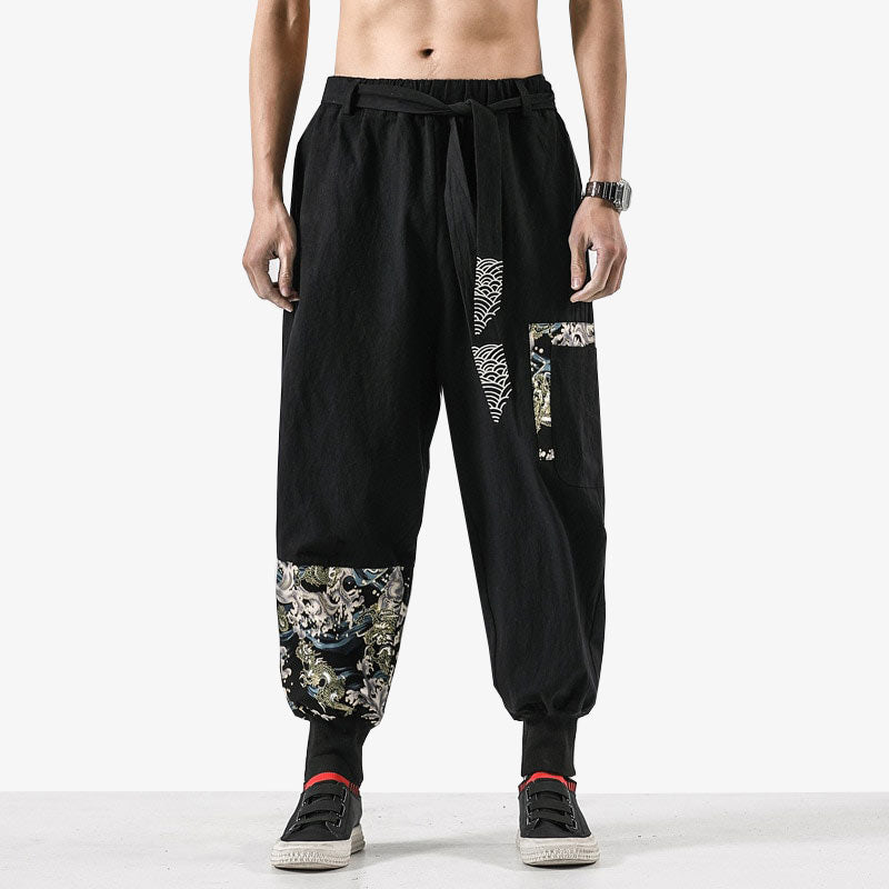 Cet habit noir est un pantalon traditionnel homme. Ce bas est cousi avec des motifs de dragons japonais et le symbole seigaiha du pays du soleil levant