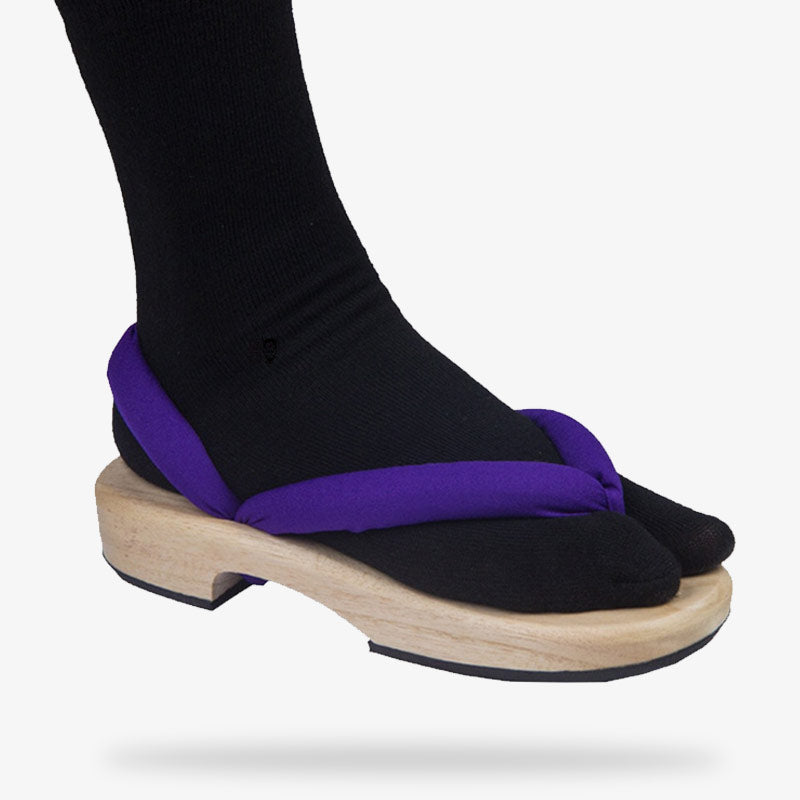 Cette chaussure japonaise est une sandale ninja en bois qui se porte avec une chaussette tabi de couleur noir