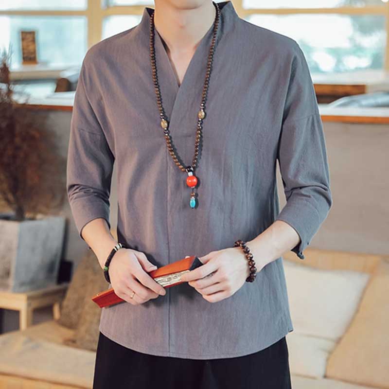 Un homme porte un shirt gris japonais avec des accessoires. Style zen, casual et décontracté. Le tee-shirt japonnais est en lin