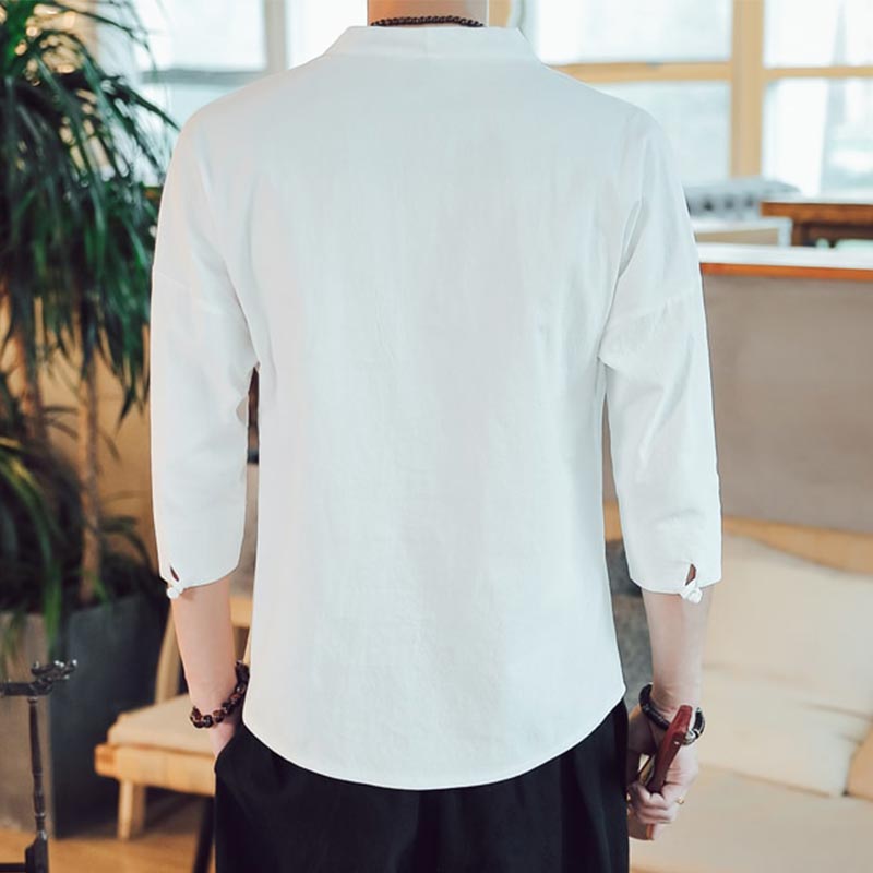 Un homme de dos porte un tshirt Japan Style zen de couleur blanche. Il est debout dans son salon de Yoga