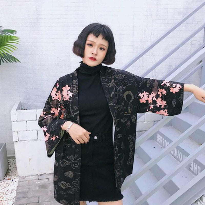 Une fille porte une veste kimono noir avec des motifs japonais de fleurs de sakura